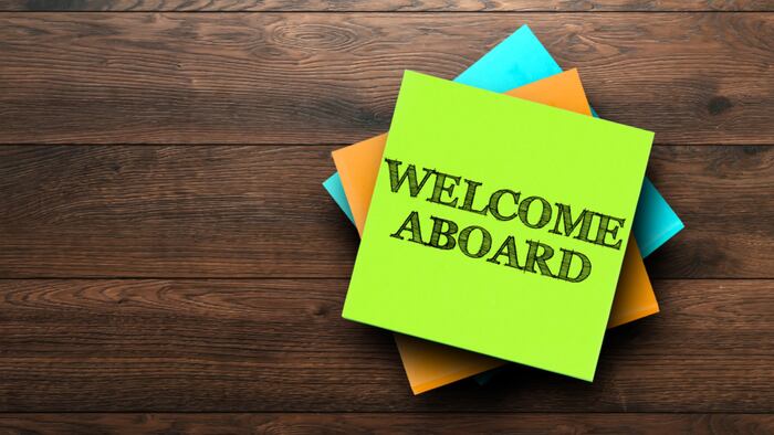 Welcome Aboard, the phrase is written on multi-colored stickers, on a brown wooden background. Business concept, strategy, plan, planning.