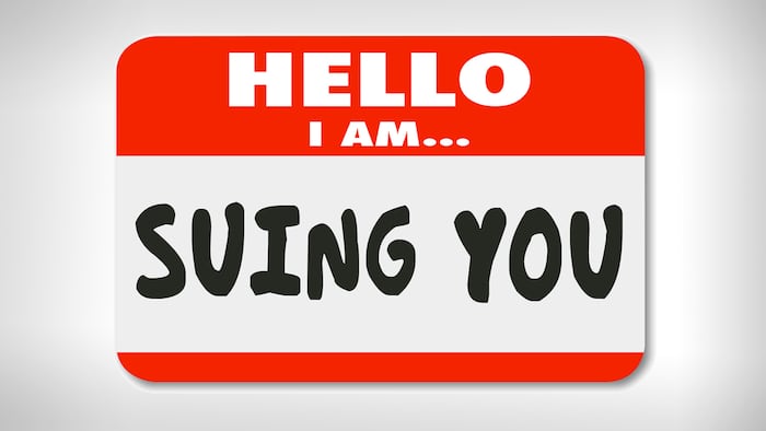 Hello I Am Suing You words on a name tag sticker informing that someone is bringing a lawsuit against you in a court of law