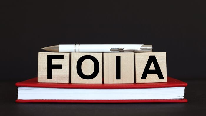 FOIA on wooden blocks balanced on red book.
