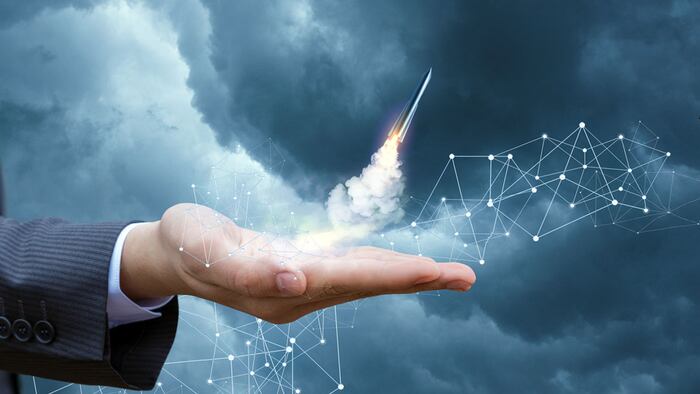 Rocket takes off from the hand of the businessman. Concept of start up.