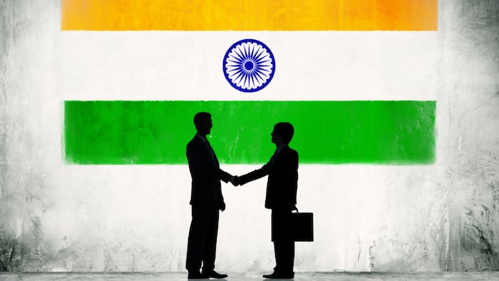 Two Businessmen Shaking Hands With Flag of India