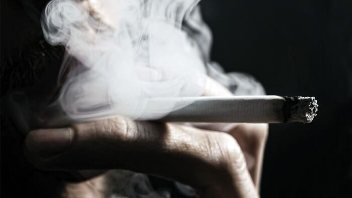 smoking cigarette in the hand of young man close up