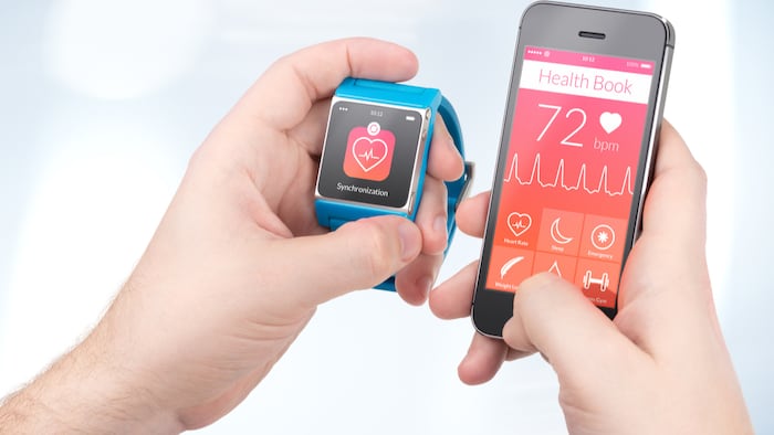 Data synchronization of health book between smartwatch and smartphone in male hands
