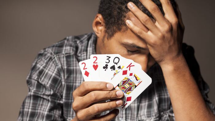 young man shows bad poker cards