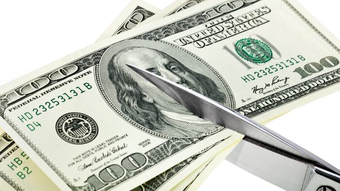 Dollars are cutting with scissors on a white background.