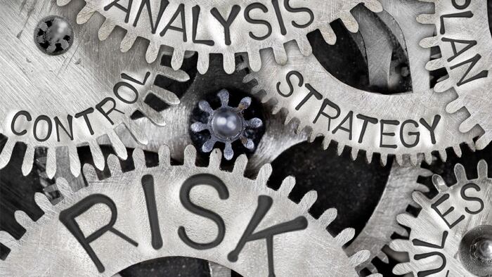 Macro photo of tooth wheel mechanism with RISK concept related words imprinted on metal surface - Image