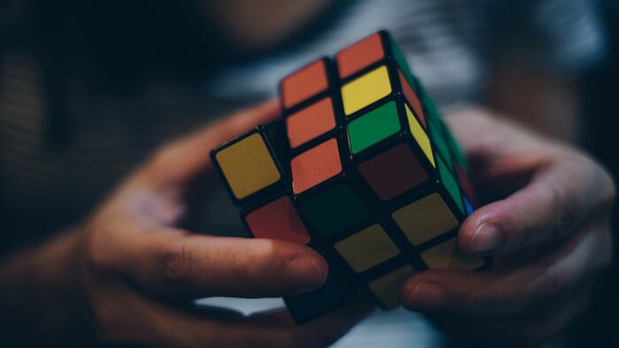 KORONADAL CITY, PHILIPPINES – JANUARY 28, 2017: Rubik's Cube was invented in 1974 by Hungarian sculptor and professor of architecture Erno Rubik. Hands of a young lady trying to solve the puzzle. - Image