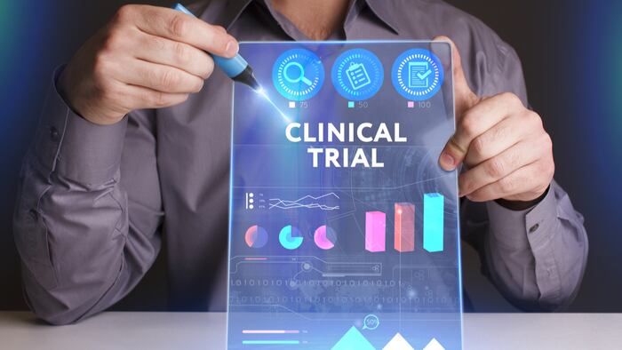 Young businessman working on a virtual screen of the future and sees the inscription: Clinical trial