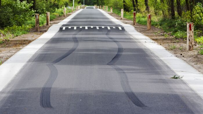 Skid marks in front of speed bump on a asphalt country road