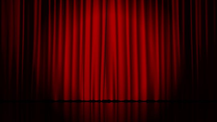 Empty stage with red curtains and spotlight