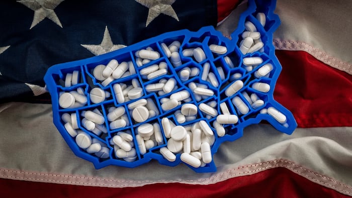 Opioid epidemic concept art with the map of USA filled with oxycodone and hydrocodone pharmaceutical pills