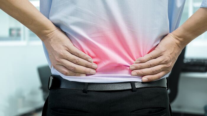 A man in blue shirt feeling pain on his back. Office syndrome. Back pain from work. Herniated nucleus pulposus. spine pain. spinal degeneration. - Image